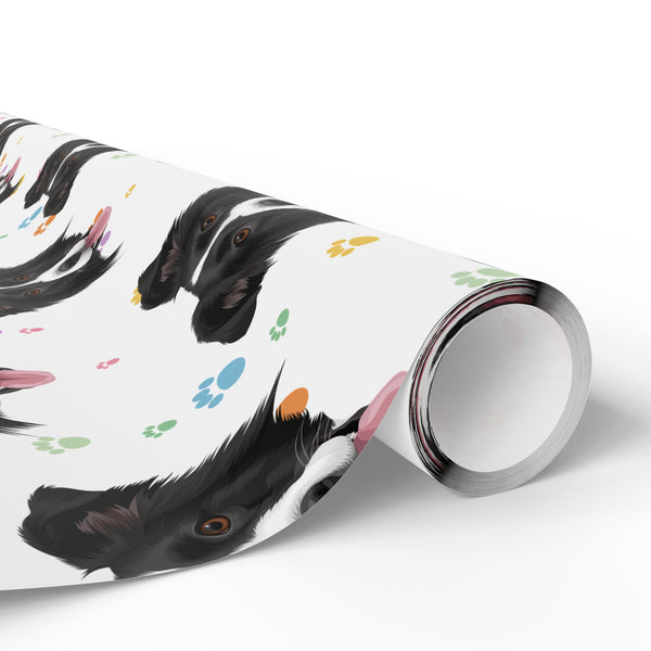 A roll of wrapping paper featuring a playful pattern of black and white dog head and colorful paw prints, shown on a clean white background.