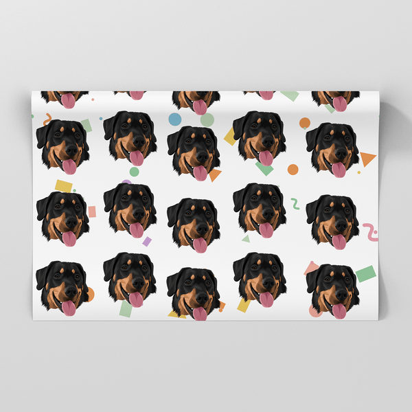 A rectangular sheet of wrapping paper featuring a repeating pattern of illustrated Rottweiler dog faces with colorful confetti accents on a white background, shown against a light gray backdrop.