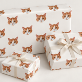 repeating orange and white cat face on three presents with white bows on light grey background